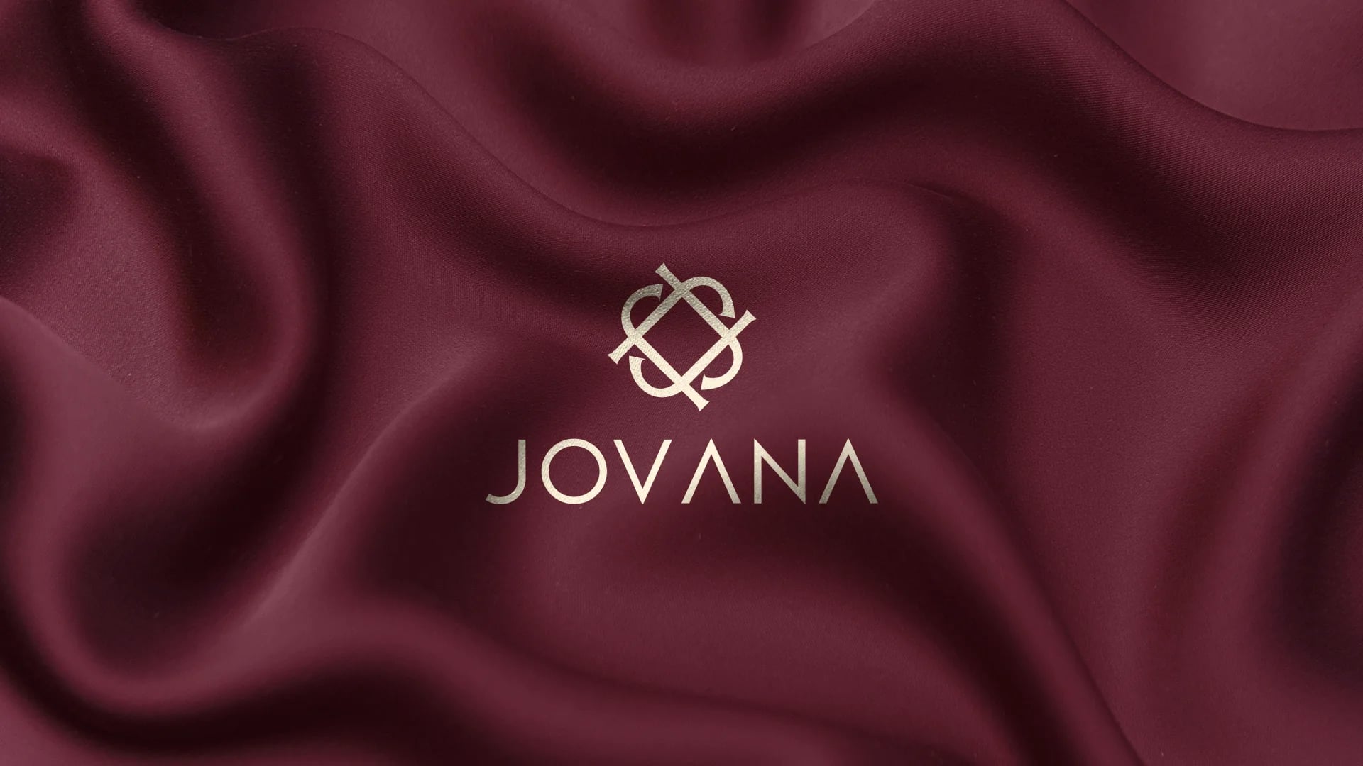 Jovana luxury fashion brand identity cover: cream monogram logo on burgundy silk
