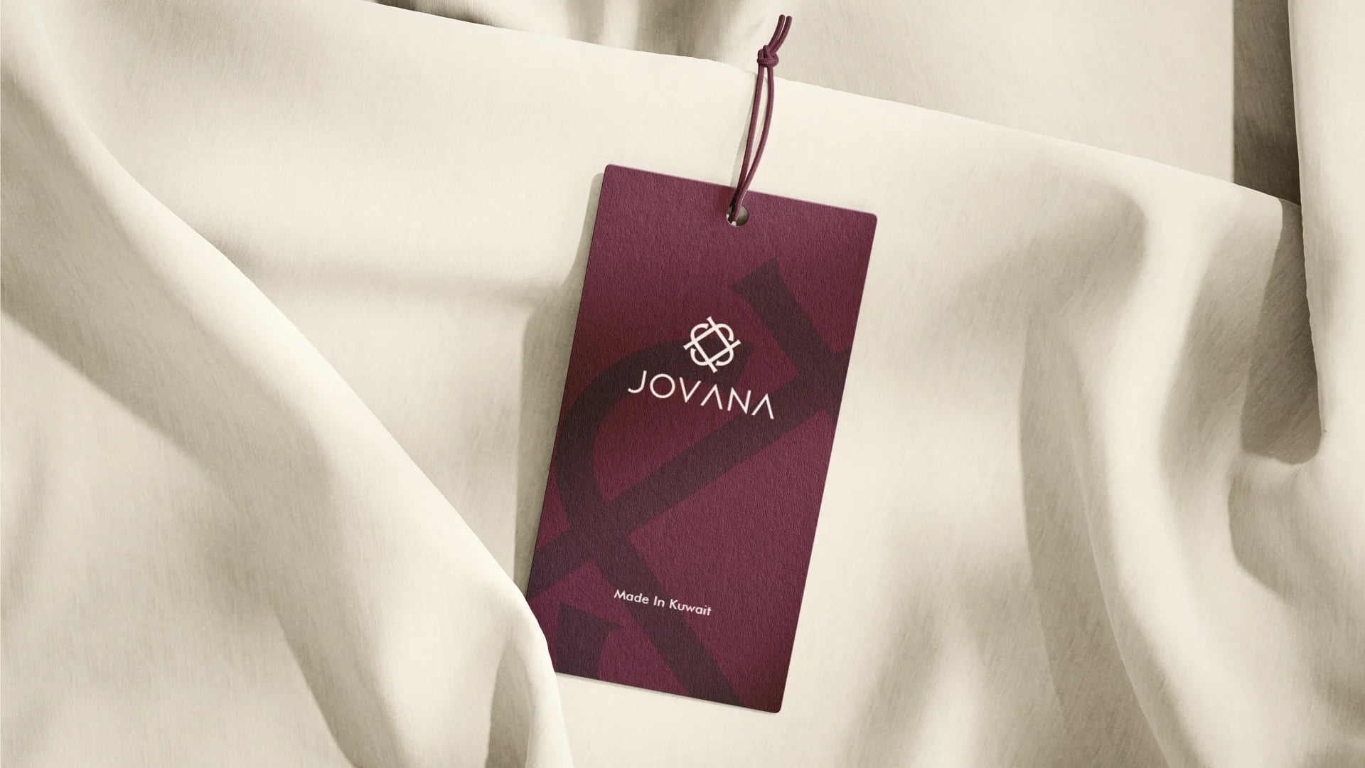 Jovana burgundy clothing hang tag on cream fabric